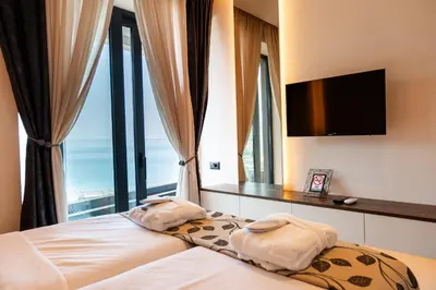 a bedroom with a bed with a large window at Apartman Katica in Becici