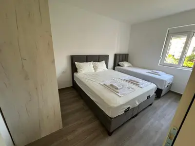 a bedroom with two beds and a window at Apartmani Aki 6 in Sutomore