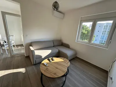 a living room with a couch and a table at Apartmani Aki 5 in Bar