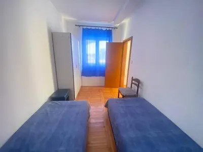 two beds in a small room with a window at Peaceful Apartment with a Sea View, in Becici in Becici