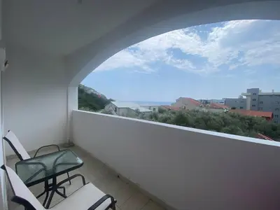a balcony with two chairs and a window at Peaceful Apartment with a Sea View, in Becici in Becici