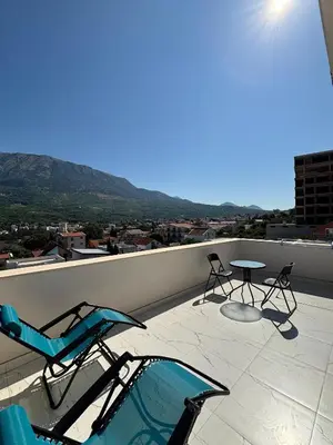 a patio with chairs and a table on a roof at Apartmani Kula in Pečurice