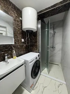 a washing machine in a bathroom with a sink at Apartmani Kula in Pečurice