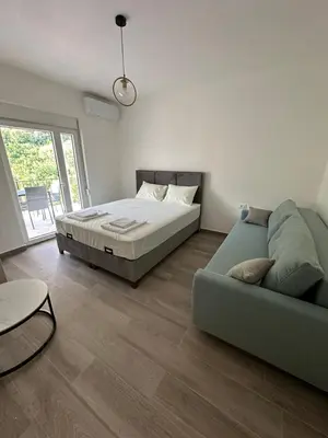 a bedroom with a bed and a couch at Apartmani Aki 4 in Bar