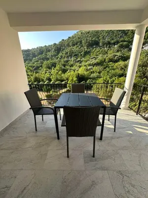 a table and chairs on a patio with a view at Apartmani Aki 4 in Bar
