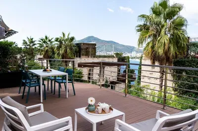 a balcony with chairs and tables and a view of the water at Dukley Montesun Apartments in Budva