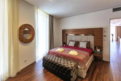 a bedroom with a large bed and a large window at Dukley Montesun Apartments in Budva