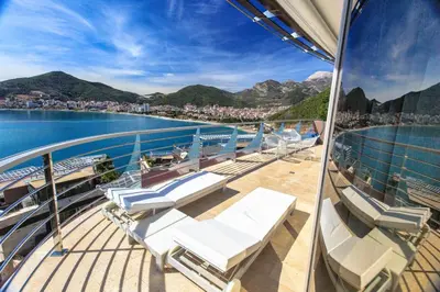 a balcony on a cruise ship with chairs and the water at Dukley Montesun Apartments in Budva