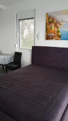 a bedroom with a purple bed with a window at Apartment 7 in Bar, Susanj