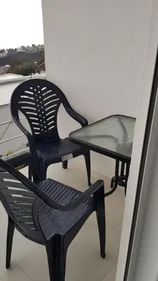 two black chairs and a glass table on a balcony at Apartment 7 in Bar, Susanj