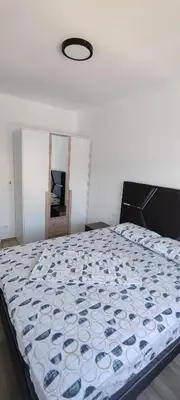 a bedroom with a bed with a blue and white comforter at Sea apartman in Bar