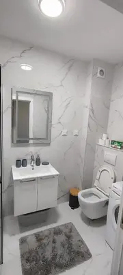 a bathroom with a toilet and a sink and a mirror at Sea apartman in Bar