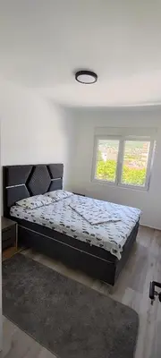 a bedroom with a bed in a room with two windows at Sea apartman in Bar