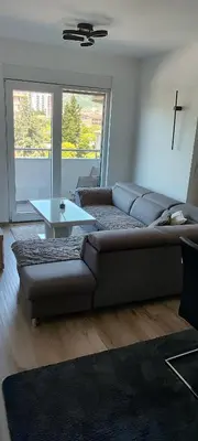 a living room with a couch and a table at Sea apartman in Bar