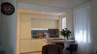 a kitchen with a sink and a counter with chairs at Comfort in Budva