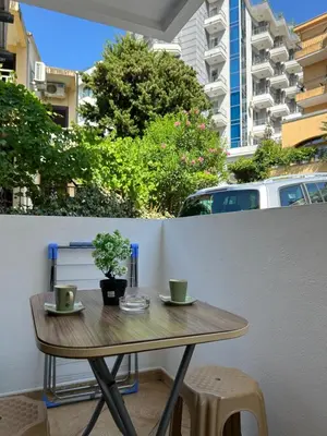 a table with two cups and a plant on a balcony at Sunny stay Budva in Rafailovici