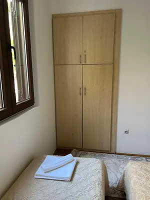 a bedroom with two beds and a cabinet with towels at Sunny stay Budva in Rafailovici