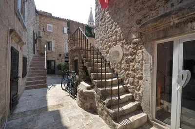a stone staircase in a stone building with a bicycle at Budva Old City Central Studio Private in Budva