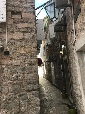 an alley in an old stone building with a street light at Budva Old City Central Studio Private in Budva