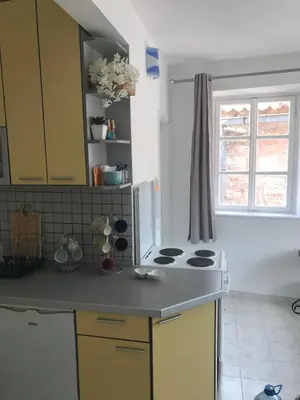 a kitchen with yellow cabinets and a stove top oven at Budva Old City Central Studio Private in Budva