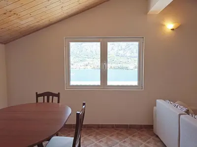 a dining room with a table and a window at Spacious apartment Kotor in Kotor
