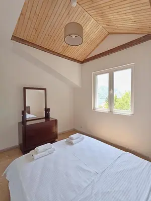 a bedroom with a large bed and a mirror at Spacious apartment Kotor in Kotor