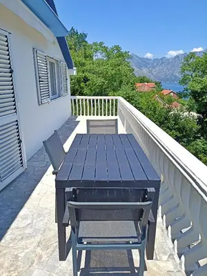 a picnic table on the balcony of a house at Spacious apartment Kotor in Kotor