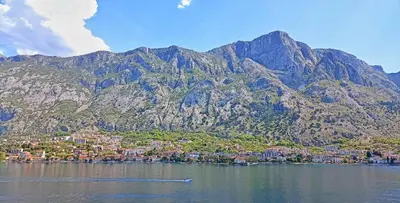 a city on the water with mountains in the background at Spacious apartment Kotor in Kotor