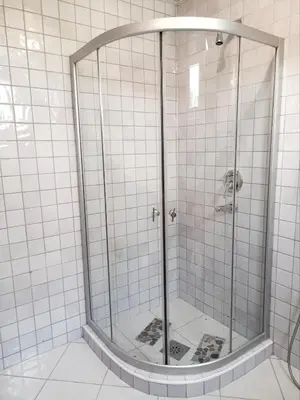 a shower in a bathroom with white tiles at Spacious apartment Kotor in Kotor