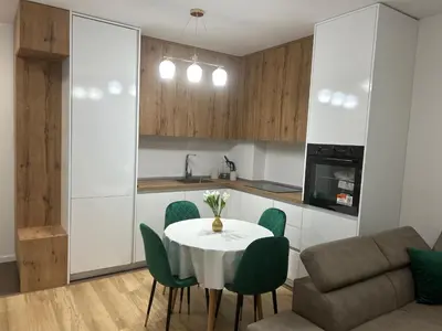 a kitchen and dining room with a table and green chairs at Pearl Wave-Apartment in Ulcinj
