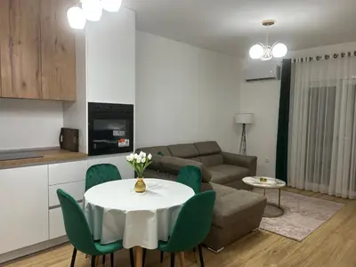 a living room with a white table and green chairs at Pearl Wave-Apartment in Ulcinj