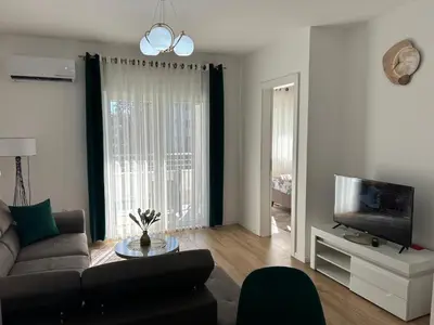a living room with a couch and a tv at Pearl Wave-Apartment in Ulcinj