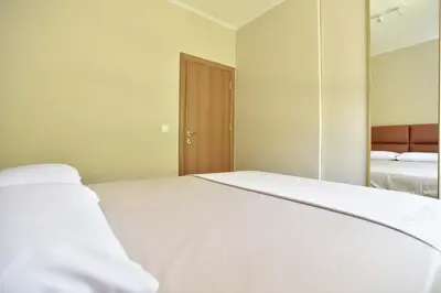 a bedroom with a white bed and a mirror at Comfy one-bdr apartment Sara in Budva