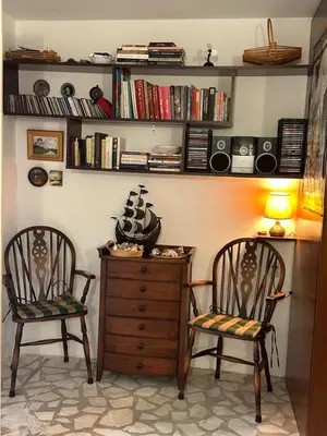 a room with two chairs and a dresser and shelves at Iskra house - Perazica Do in Perazića Do