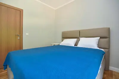 a bedroom with a bed with a blue blanket at Comfy one-bdr apartment Staša in Budva