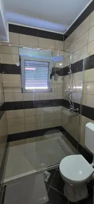 a bathroom with a toilet and a glass shower at KASIJA Apartman in Podgorica