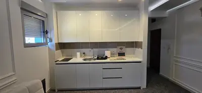 a kitchen with white cabinets and a sink at KASIJA Apartman in Podgorica