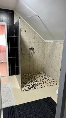 a bathroom with a shower with black and white tile at Adria spa Rafailovici in Becici