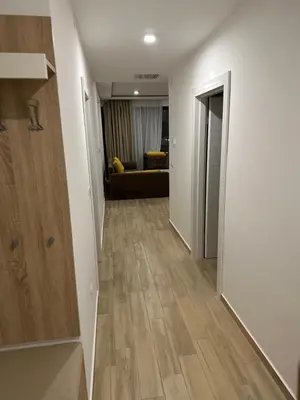 a hallway leading to a living room with wood floors at AB LUX Apartmani 401 in Sutomore