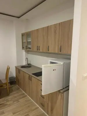 a kitchen with wooden cabinets and a white refrigerator at AB LUX Apartmani 401 in Sutomore