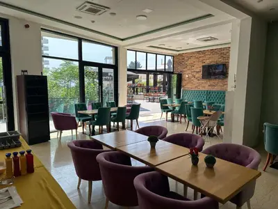 a restaurant with tables and chairs and windows at AB LUX Apartmani 401 in Sutomore