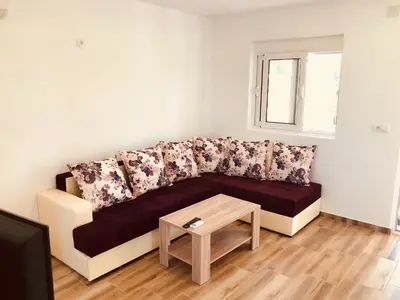 a couch in a living room with a table at Delfini Holiday Homes in Ulcinj