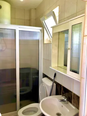 a bathroom with a toilet and a sink and a mirror at Delfini Holiday Homes in Ulcinj