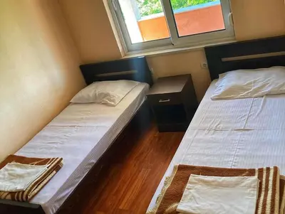 two twin beds in a small room with a window at Delfini Holiday Homes in Ulcinj