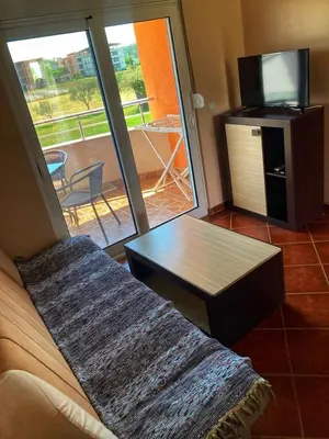 a living room with a couch and a table and a television at Delfini Holiday Homes in Ulcinj