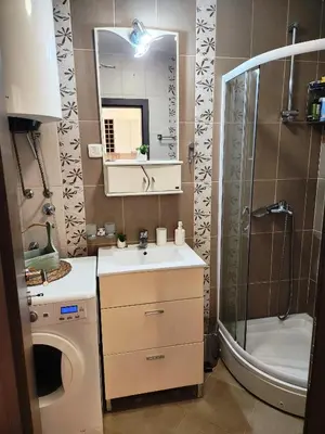a bathroom with a sink and a shower and a mirror at MiraBlu - New Modern Apartment - FREE parking in Budva