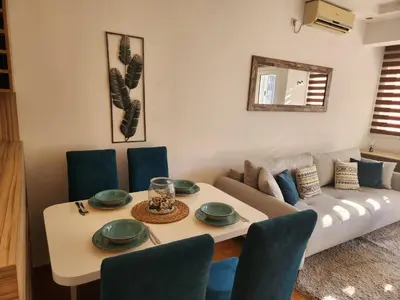 a living room with a table and a couch at MiraBlu - New Modern Apartment - FREE parking in Budva