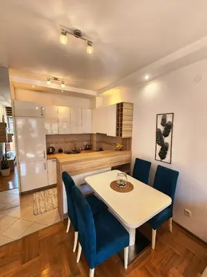 a kitchen and dining room with a table and chairs at MiraBlu - New Modern Apartment - FREE parking in Budva