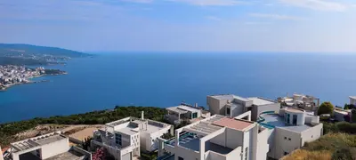 an aerial view of a white building on a hill next to the water at VISTA Kalamper MONTENEGRO in Dobra Voda