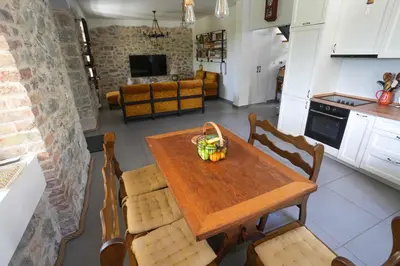 a kitchen with a table with a bowl of fruit on it at Vila Mirko in Kotor